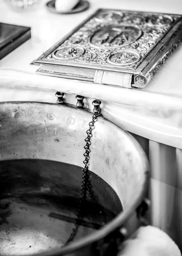 Photographie de l'eau bénite, à proximité de la Bible. dans une église.