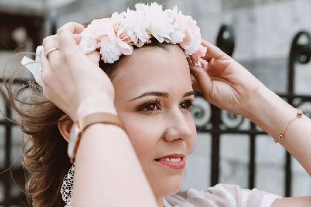 Portrait photo de la future mariée qui enfile sa couronne de fleurs