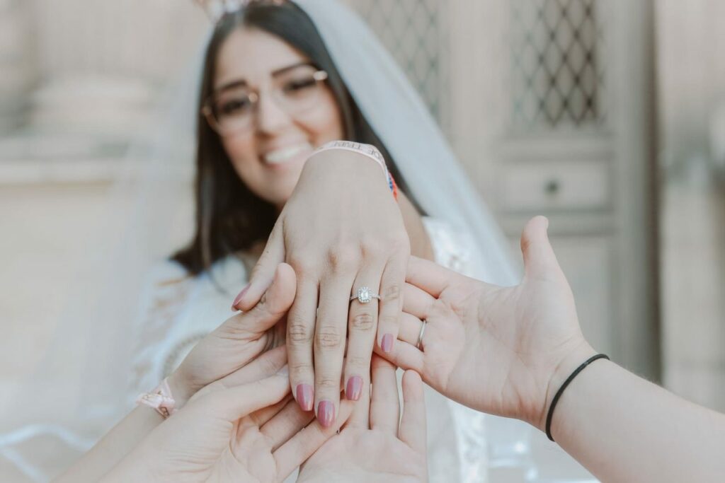 La mariée présente sa bague de fiançailles à ses proches, témoins et demoiselles d'honneur du mariage lors d'un shooting evjf