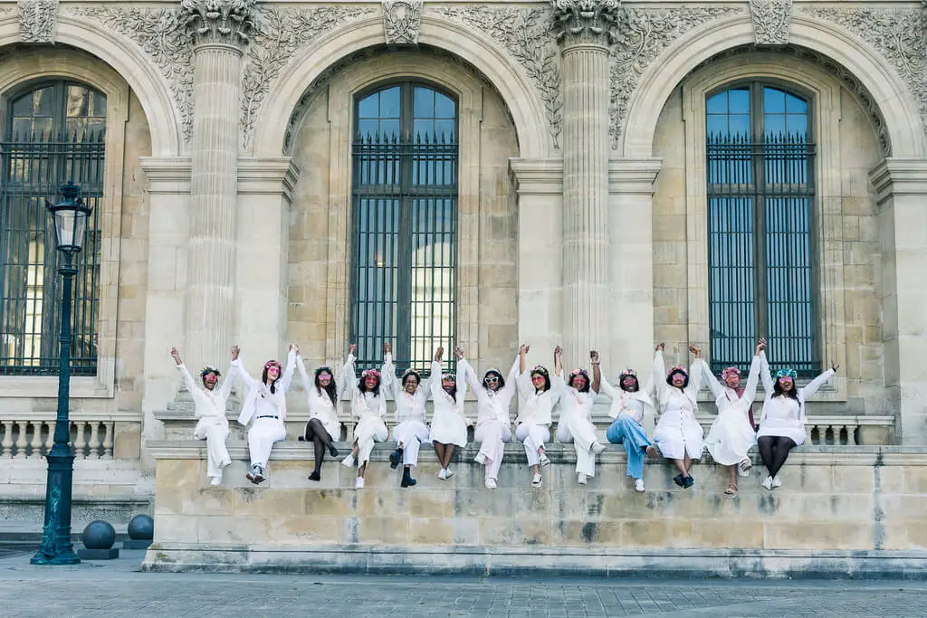La mariée et ses proches font une hola en levant les bras lors d'un shooting evjf à Paris avec lesphotosdebela.fr